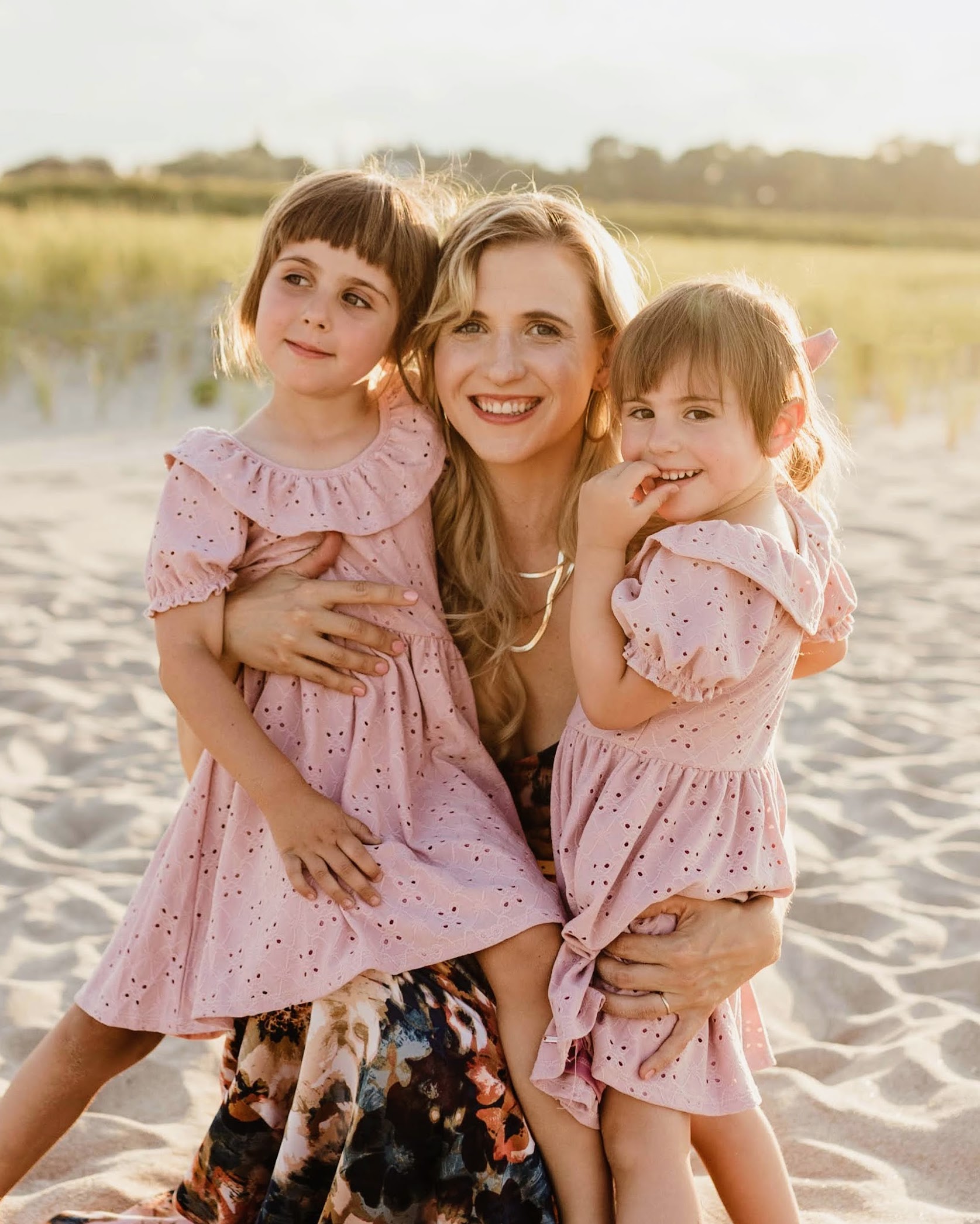 Marysia, doula and mother of three, with her daughters on the beach at sunset